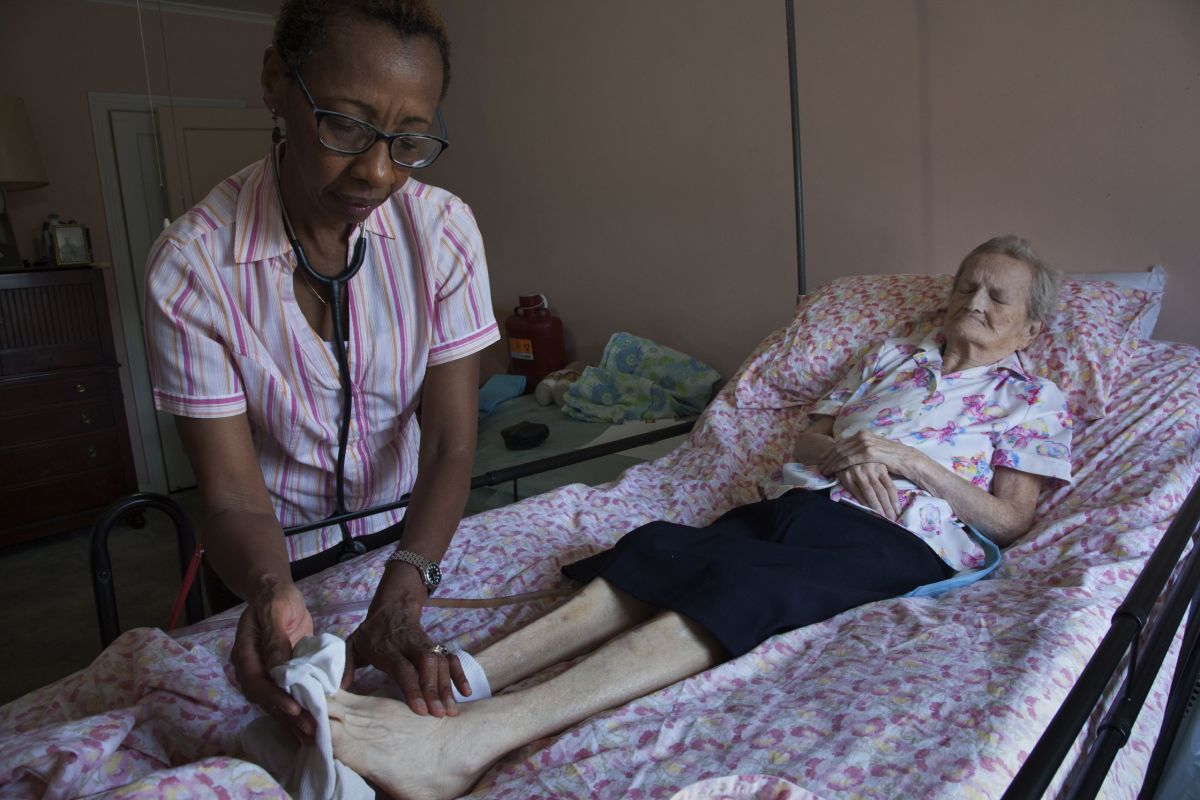 Heather assesses the pedal pulse of Ruth, a patient from Marine Park, Brooklyn. She was ninety-three years old when this photograph was taken.